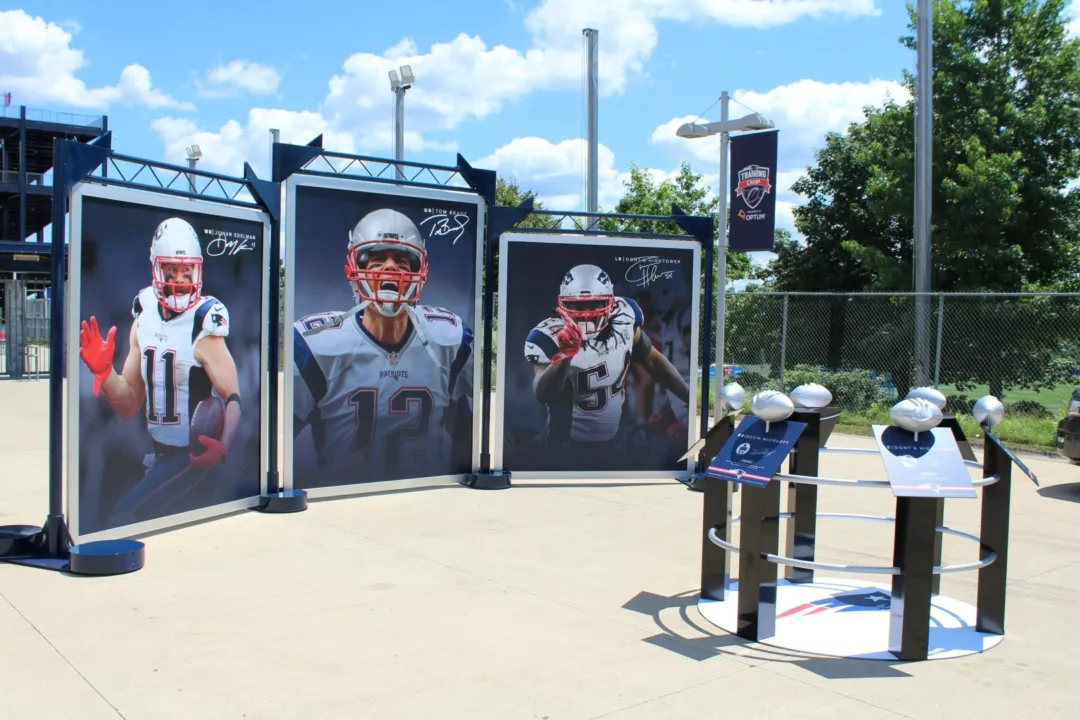 Tri-panel banner displays outside of a New England Patroit's game with player graphic banners.