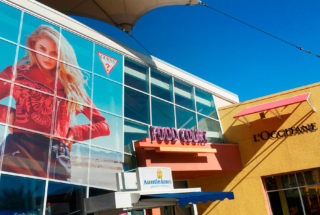Custom window decals on a storefront at an outlet mall.