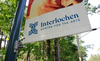 A custom light pole banner and BannerSaver bracket for Interlochen Arts Academy that says Interlochen Center for the arts