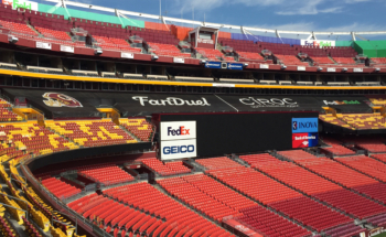 Mesh banners as custom seat covers for empty stadium seats.