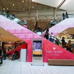 Custom printed wall decals wrapping an escalator in a mall.