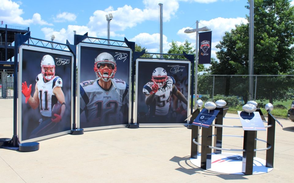 Tri-panel banner displays outside of a New England Patroit's game with player graphic banners.