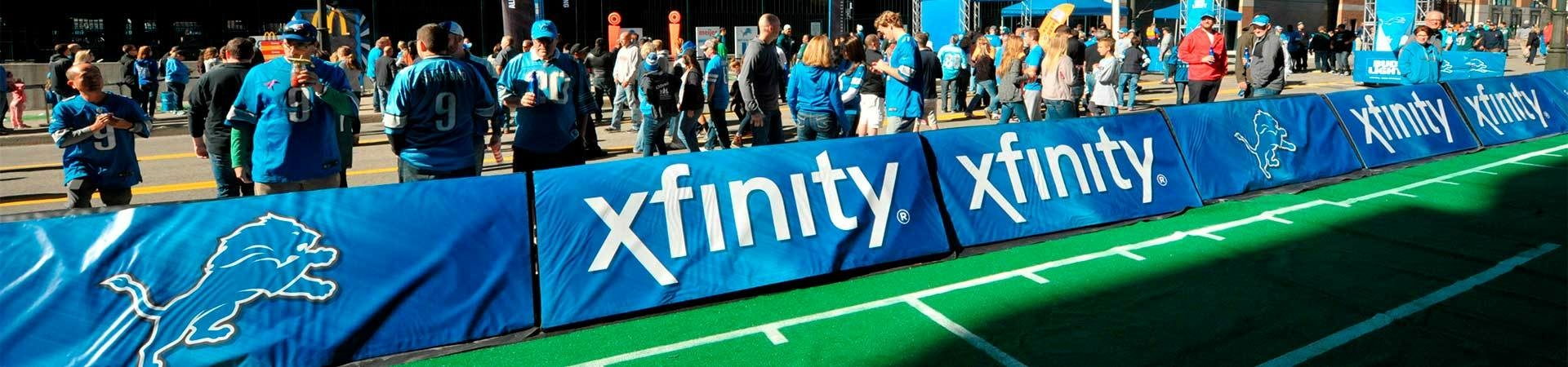 A-frame sideline signature banner displays with team logos at a Detroit Lions game.