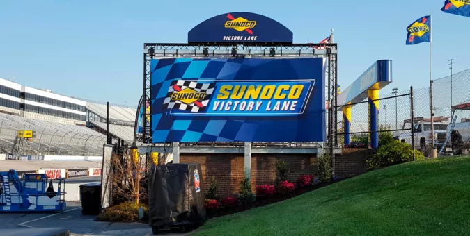 Custom event truss with mesh banner and signage for victory lane.
