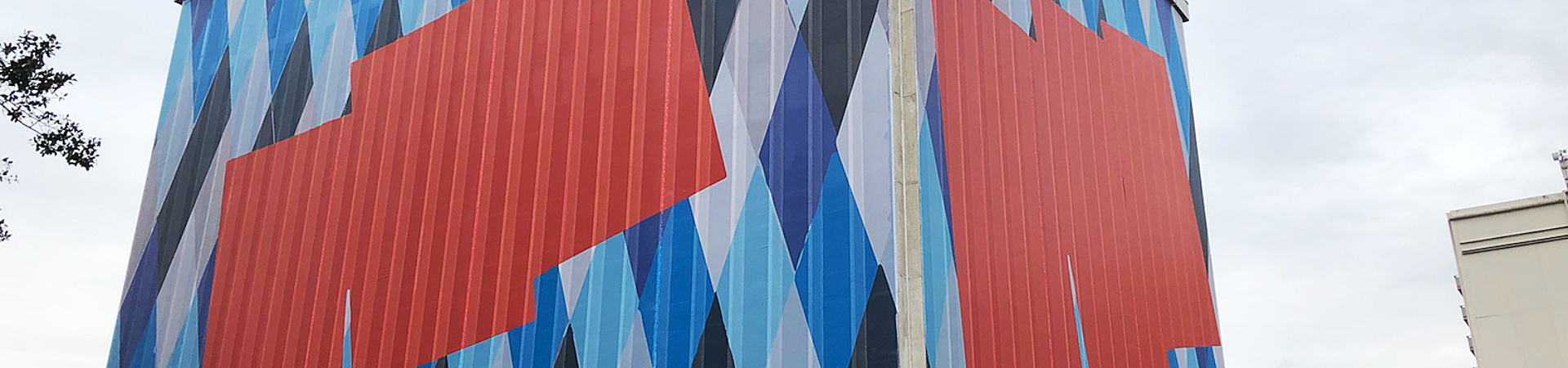 Colorful mesh building wrap surrounding an office building.