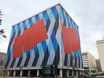 Colorful mesh building wrap surrounding an office building.