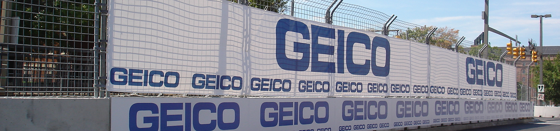 Mesh fence scrim with advertisements covering a construction site.